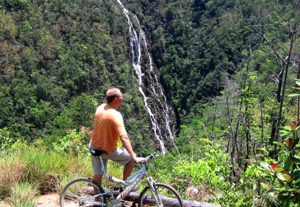 a man biking and looking at tiger creek falls